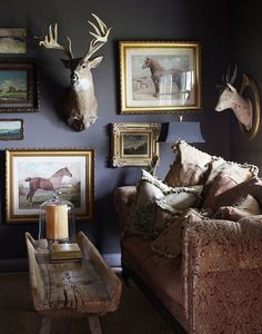 a living room filled with furniture and pictures on the wall next to a coffee table