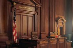 an empty courtroom with the american flag hanging on the wall