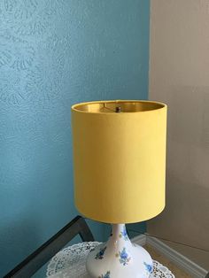 a yellow lamp sitting on top of a table next to a blue and white wall