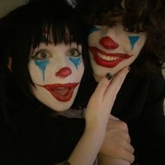 two women with painted faces pose for the camera