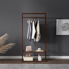 a clothes rack with several pairs of shoes on it in front of a gray wall