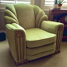 a green chair sitting on top of a carpeted floor in front of a window