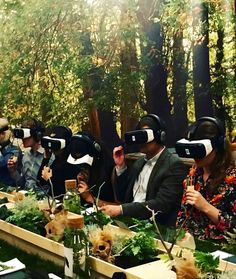 several people wearing virtual headsets sitting at a table