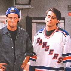 two young men standing next to each other in front of a basketball hoop and locker room