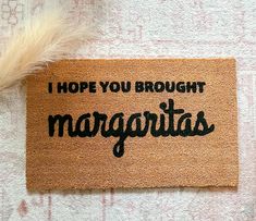 a door mat with the words i hope you brought margaritas written in black on it