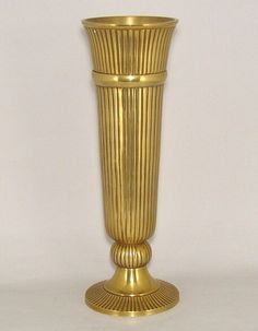 a gold vase sitting on top of a white table