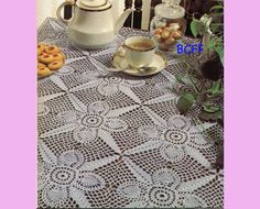 there is a doily on the table with coffee and doughnuts