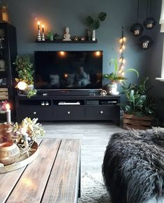 a living room filled with furniture and a flat screen tv on top of a wooden table