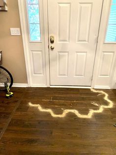 a bicycle is parked in front of a door with light coming from the floor on it