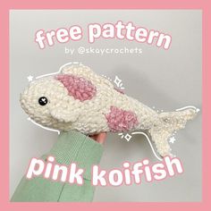 a hand holding a pink koi fish with the text free pattern by skkycrochets