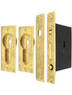 three golden door handles and two black ones with ornate designs on the front, one has a keyhole in the middle