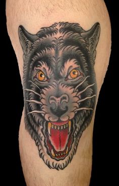 a man's leg with a black and grey tattoo of a tiger on it