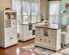 a kitchen with white cabinets and an island in the middle, along with a fireplace