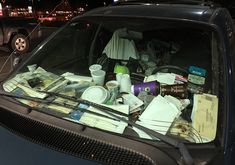 the back window of a parked car filled with papers and other items, including paper towels