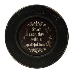 a black and gold plate with a quote on the front saying start each day with a grateful heart