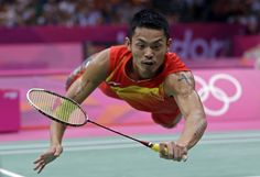 a tennis player dives to hit the ball with his racket during a match