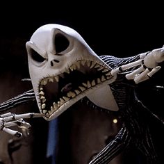 an animated skeleton with its mouth open in front of a black background and white hands