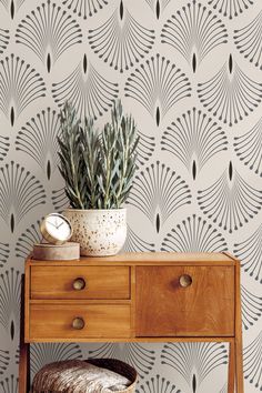 a wooden table with a plant on top of it in front of a wallpaper