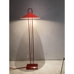 a red lamp sitting on top of a white floor