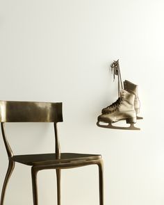 a pair of ice skates hanging on the wall next to a chair with a foot in it