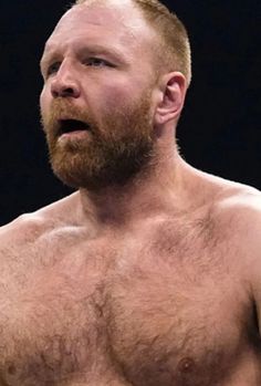 a close up of a shirtless man holding a tennis racquet