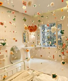 a bedroom decorated in white and orange with flowers flying from the ceiling to the bed