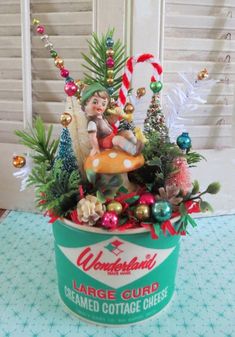 an ice cream container filled with christmas decorations and candy canes on top of a table