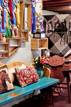 a blue bench sitting in front of a wall filled with colorful ribbons and other items