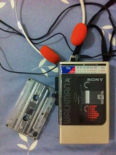 an old tape recorder and headphones laying on a bed