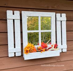 an old window is decorated with fall flowers