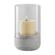 a lit candle in a glass container on a white background