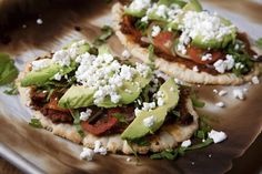 three pita breads topped with avocado and feta cheese