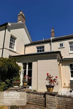 the front of a house with flowers in pots