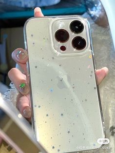 a person holding an iphone case in their hand with stars on it and glitters all over the back