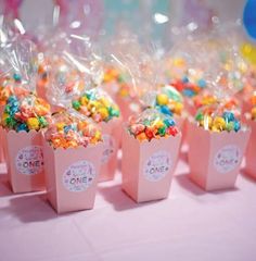 small pink bags filled with colorful candies on top of a table