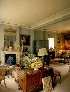 a living room filled with lots of furniture and flowers on top of a wooden trunk