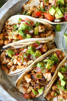 chicken tacos with avocado and salsa in a bowl on the side, ready to be eaten