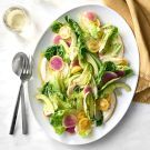 a white plate topped with lettuce and radishes