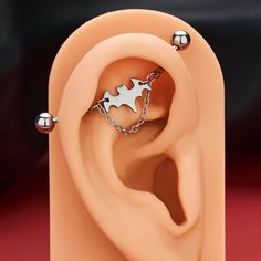 an ear is shown with two piercings attached to the top of it and chain