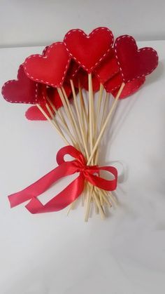 red heart shaped sticks tied to a white surface