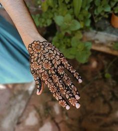 a person's hand with henna on it and flowers painted on the palm