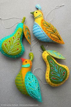 three colorful birds hanging from strings on a gray surface with string attached to the sides