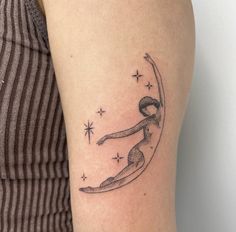 a woman with a tattoo on her arm is sitting on the crescent moon and stars