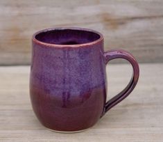 a purple mug sitting on top of a wooden table