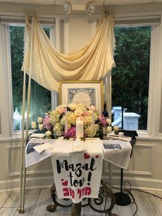 a table with flowers and candles on it in front of a window that says, march to love