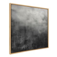 a black and white painting hanging on a wall above a wooden framed artwork piece, with an overcast sky in the background