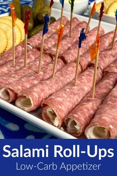 salami roll - ups on a platter with toothpicks and pickles