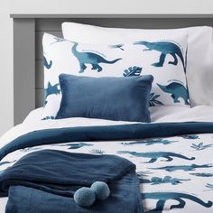 a bed with blue and white dinosaurs on it