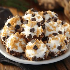 a white plate topped with cookies and marshmallows on top of a wooden table