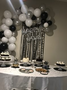 a table topped with lots of cake and balloons